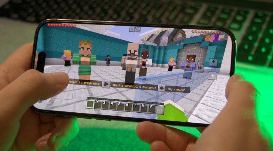 a person playing Minecraft Mobile version on an iPhone