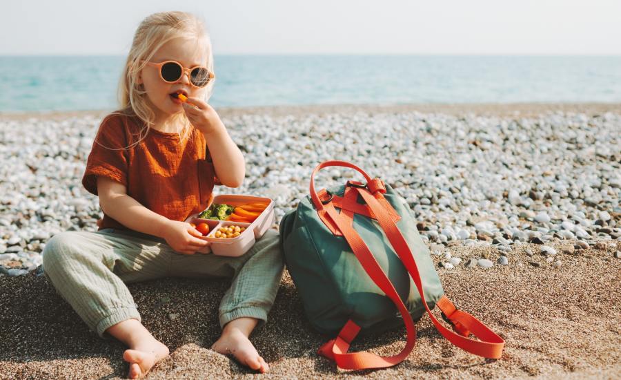 dziecko na plaży - je posiłek