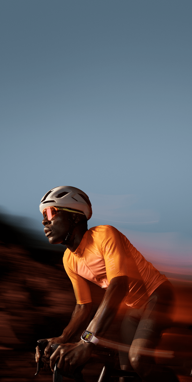 Zdjęcie osoby jadącej na rowerze z założonym na ręku Apple Watch Series 9.